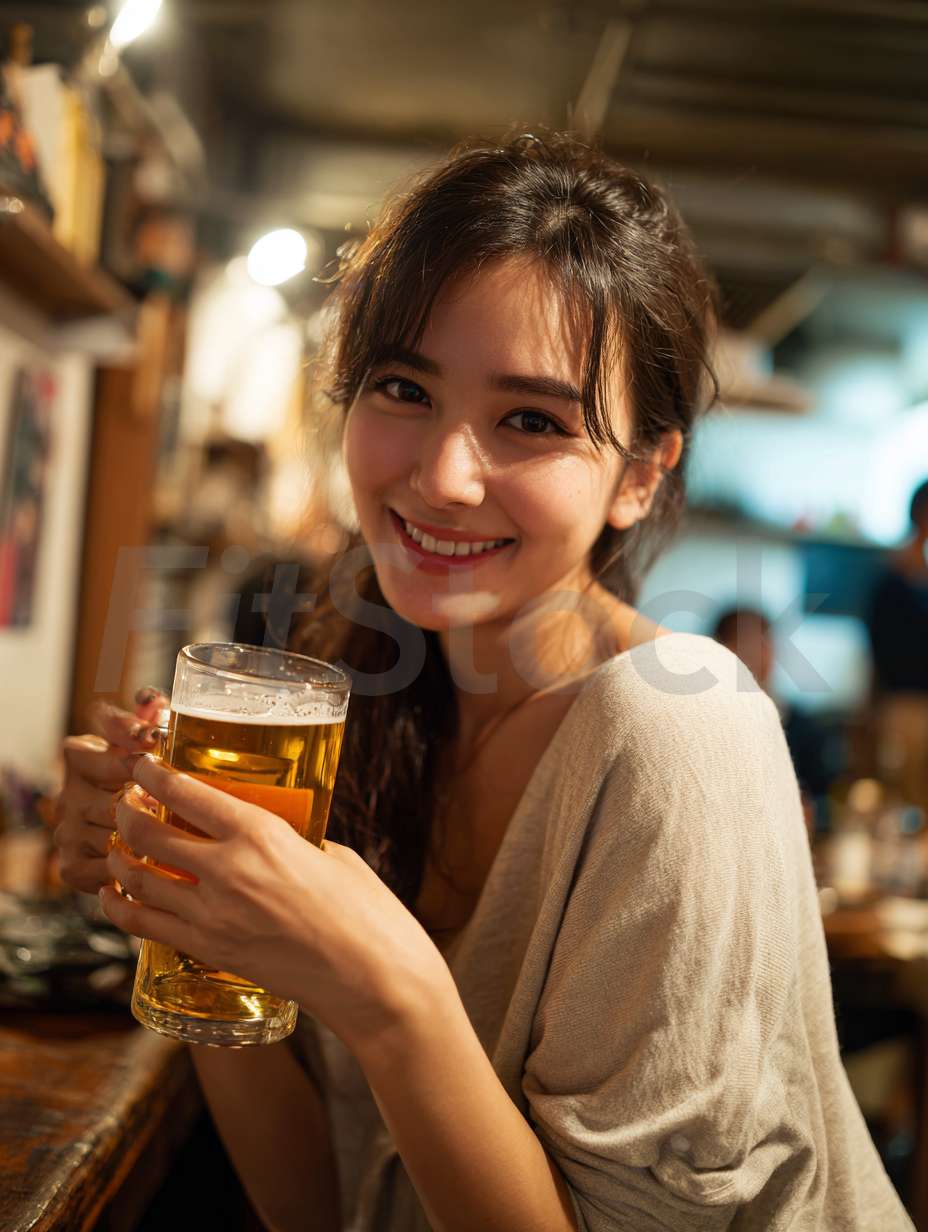 居酒屋でビールを楽しむ笑顔の女性