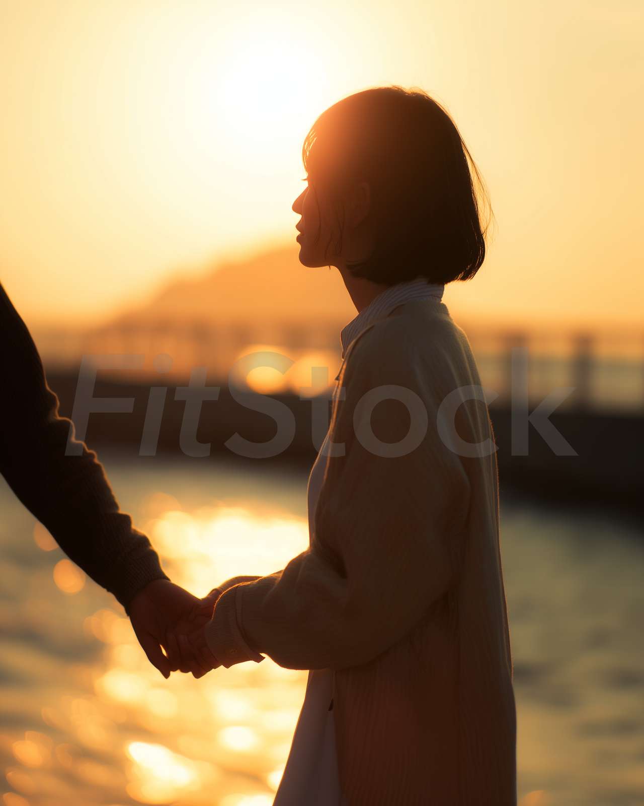 夕暮れ時に手をつなぐ二人のシルエット
