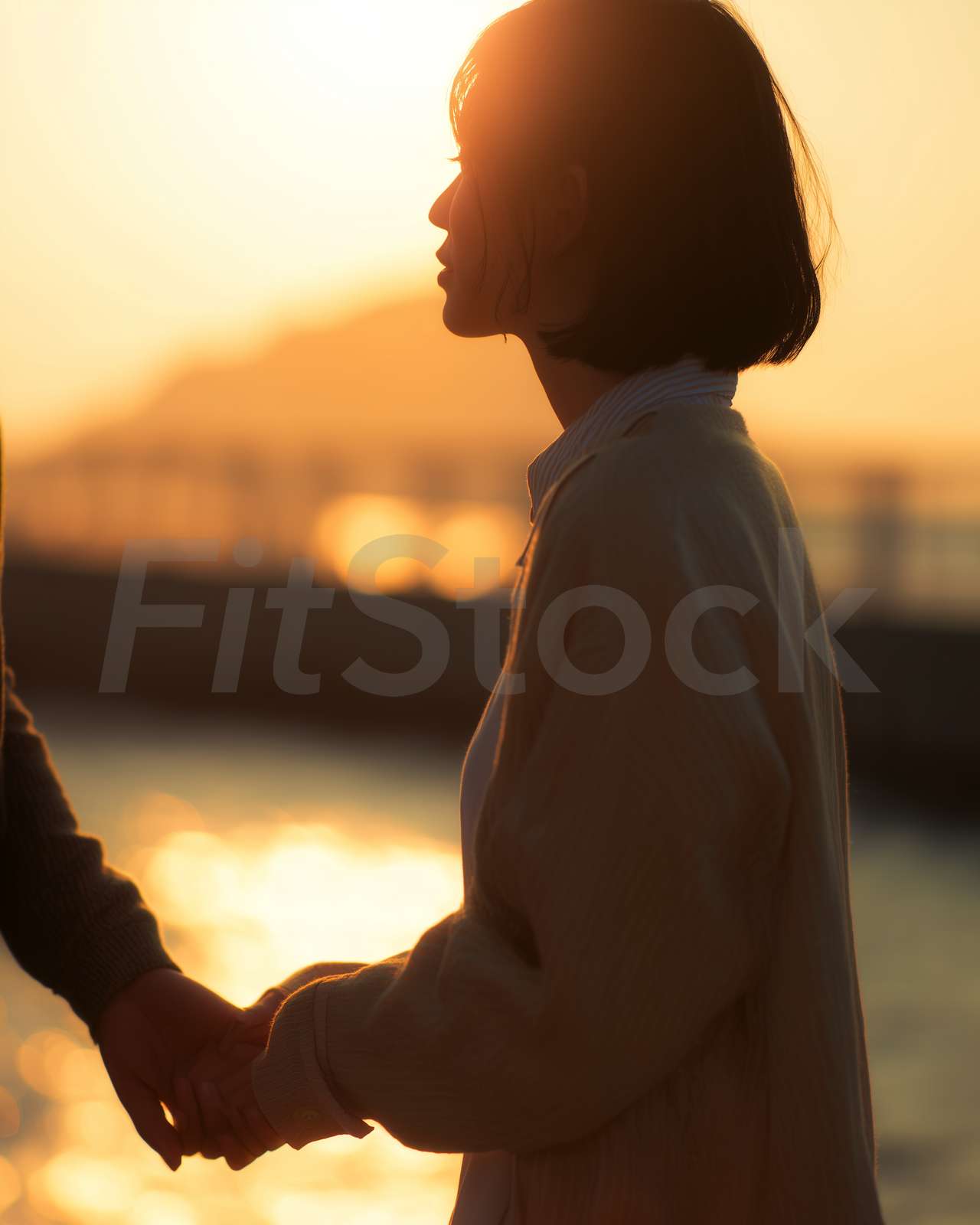 夕暮れ時に手を取り合うカップル