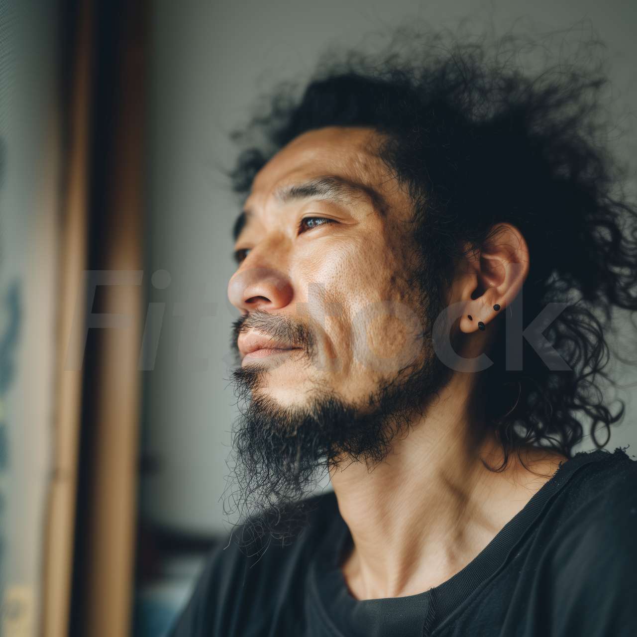 窓辺で物思いにふける髭の男性
