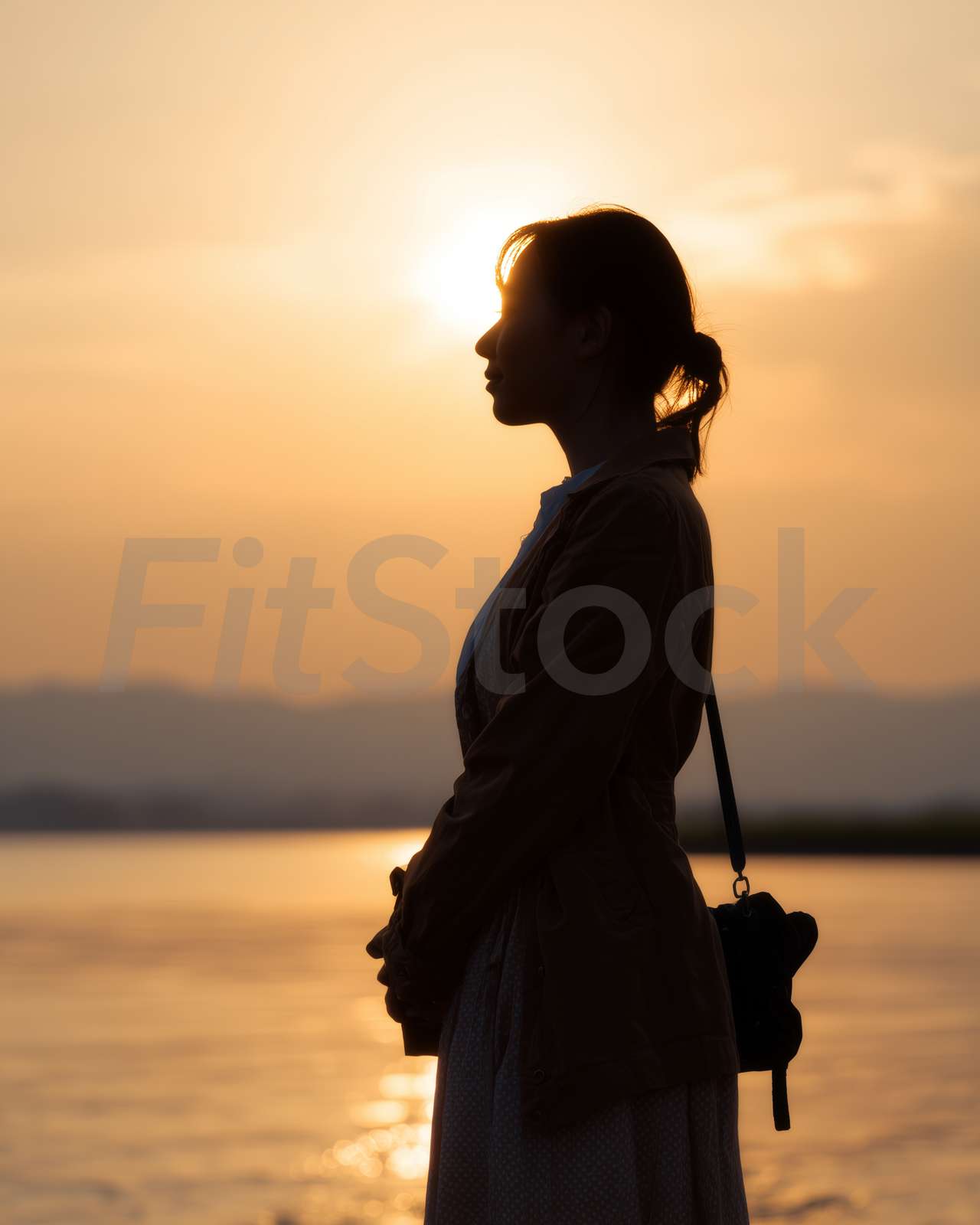夕暮れ時に佇む女性のシルエット