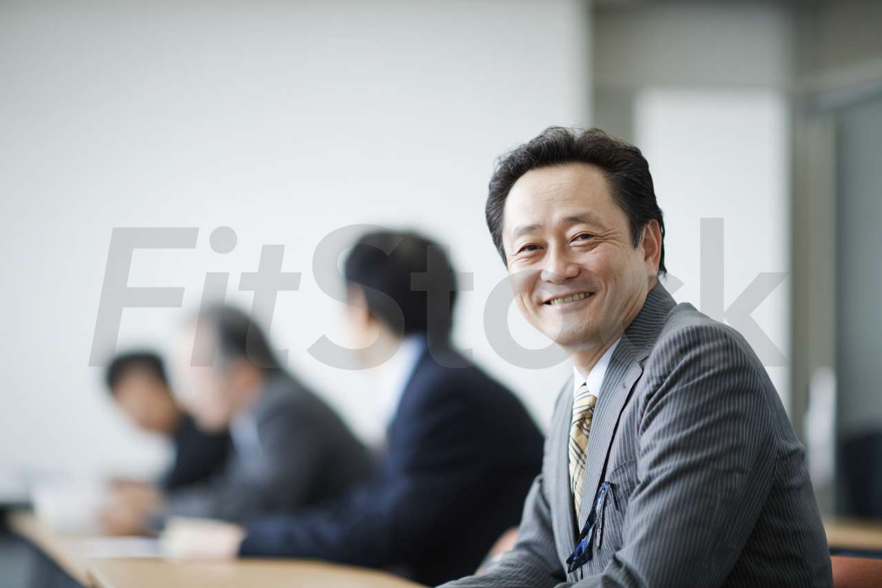 会議で笑顔を見せるビジネスマン
