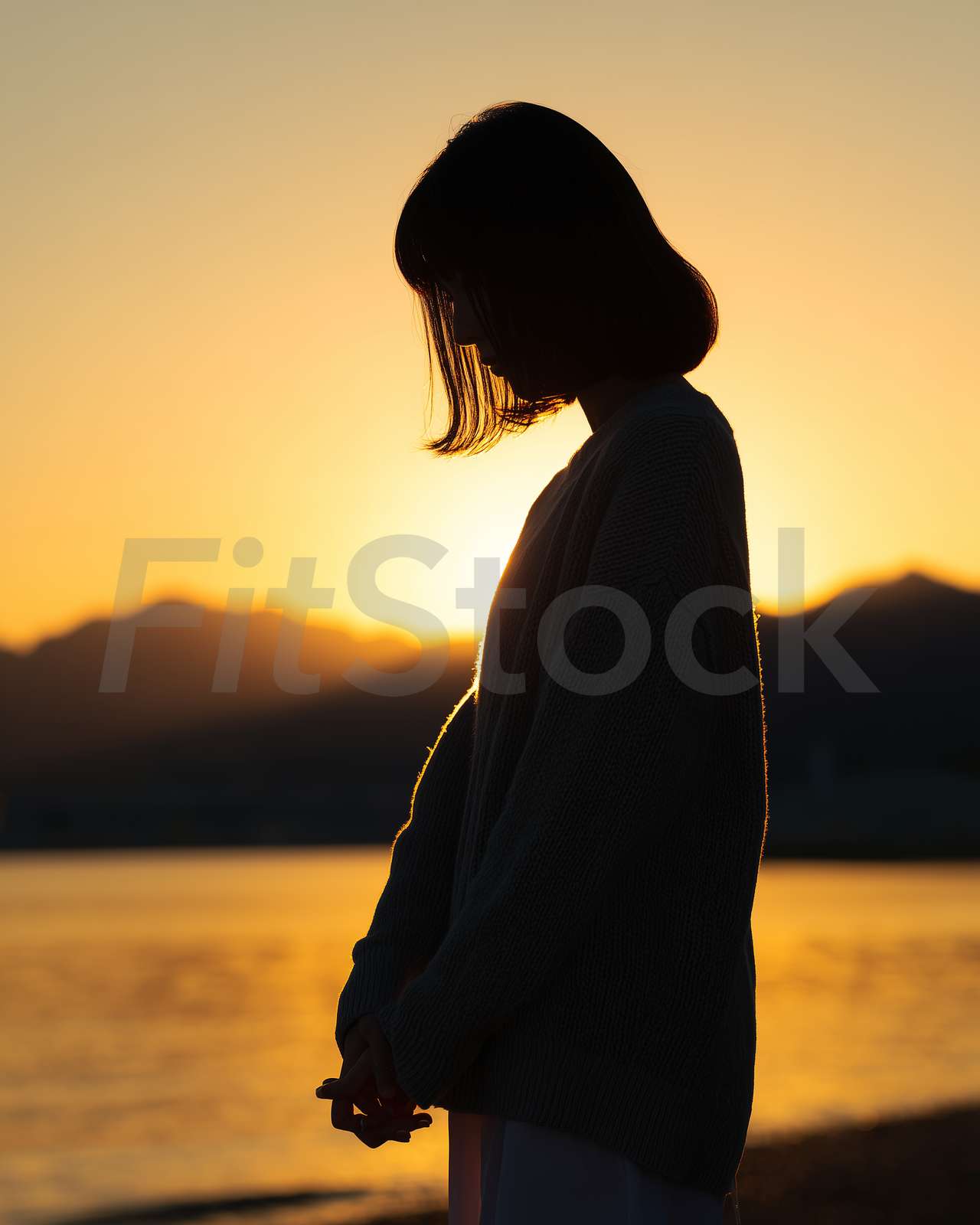夕暮れ時に佇む女性のシルエット
