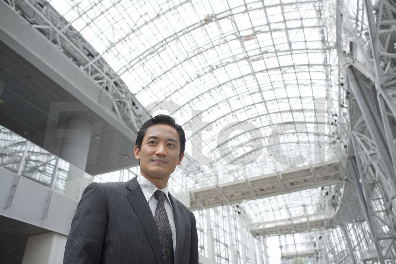 現代的なオフィスビルで微笑むビジネスマン