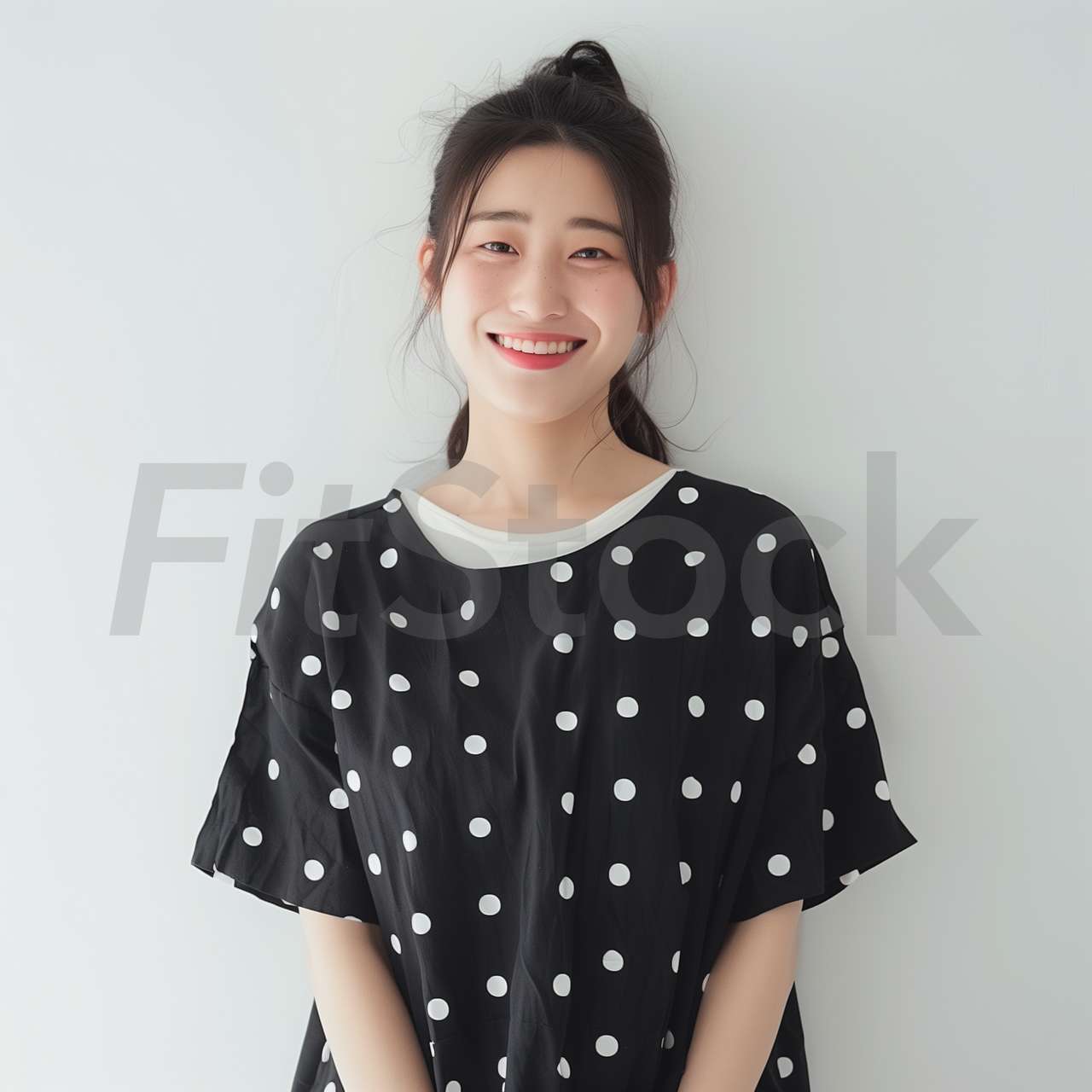 水玉模様の服を着て微笑む若い女性