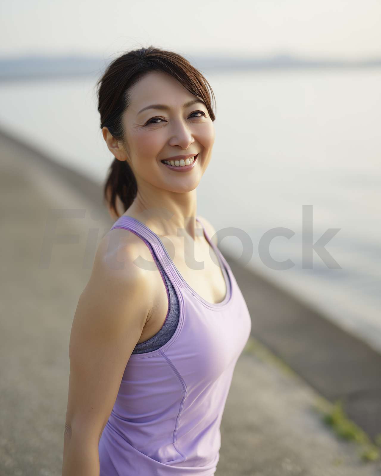 海辺で笑顔を見せるアクティブな女性