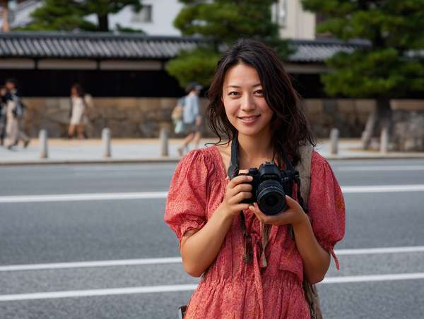 カメラを持って街を歩く笑顔の女性