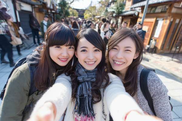 日本の観光地で笑顔で自撮りをする三人の女性