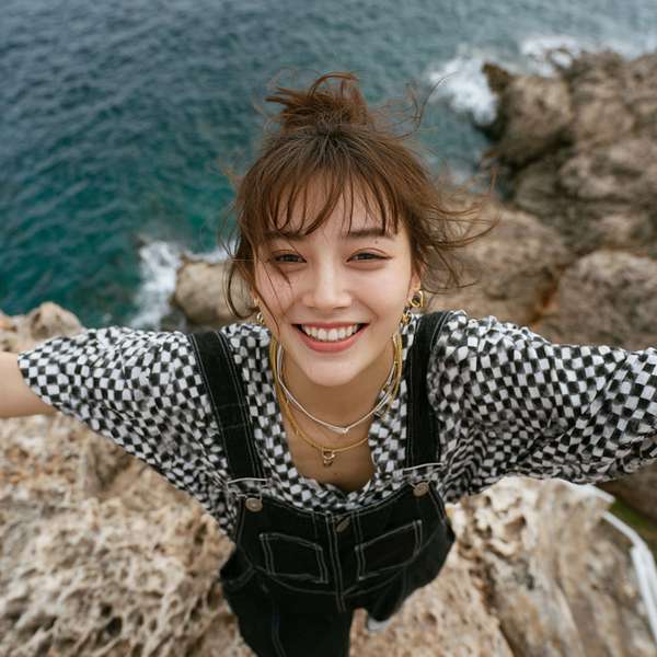 海辺で笑顔を見せる若い女性