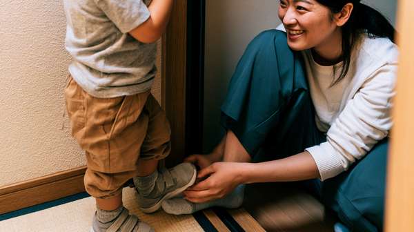 子供に靴を履かせる母親