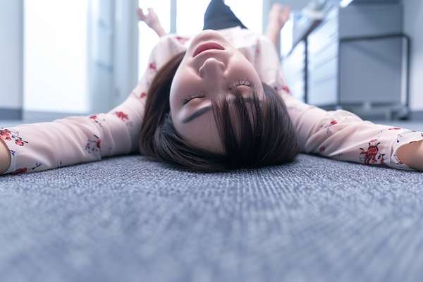 オフィスで床に倒れ込み疲れ果てた女性