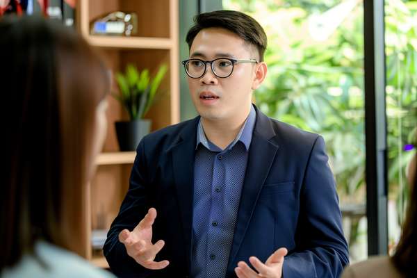ビジネス会議で意見を述べるアジア人男性