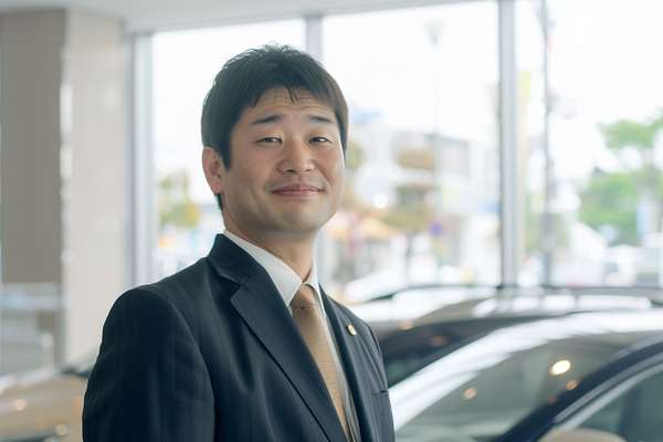 笑顔で接客するカーディーラーの男性