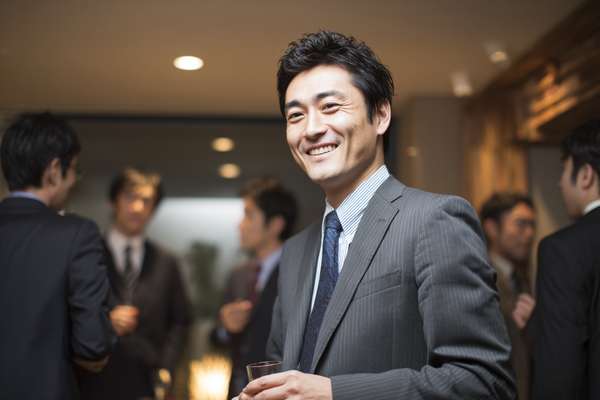 ビジネスパーティーで笑顔を見せるアジア人男性