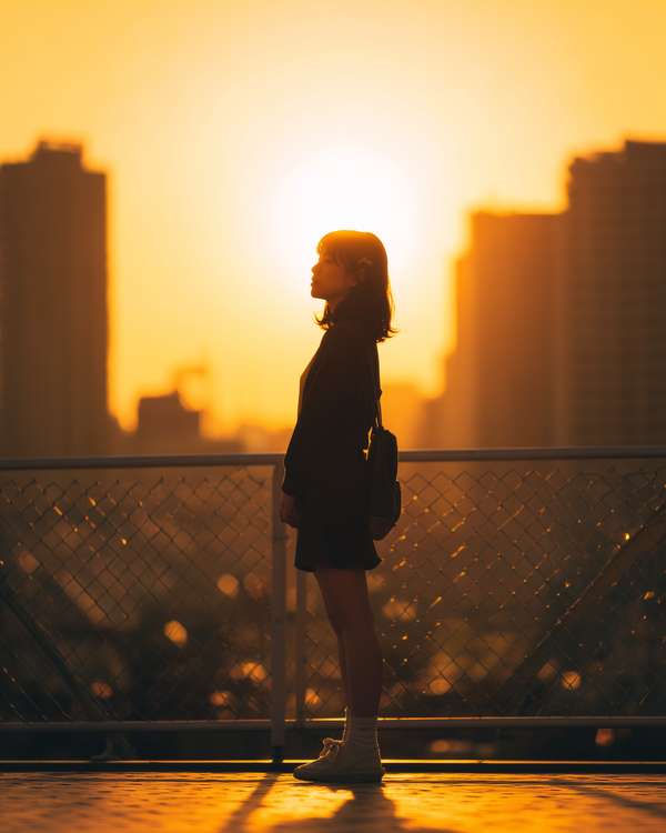 夕暮れ時に佇む女性のシルエット