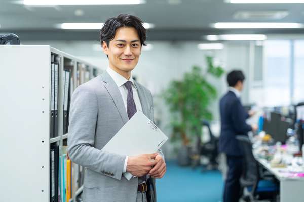 オフィスで微笑むスーツ姿のビジネスマン