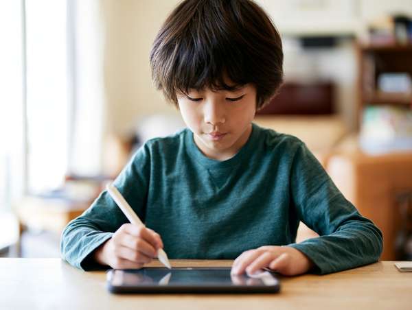 タブレットで学習する少年