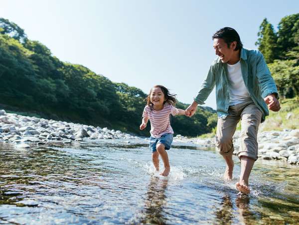 川で楽しく水遊びをする親子