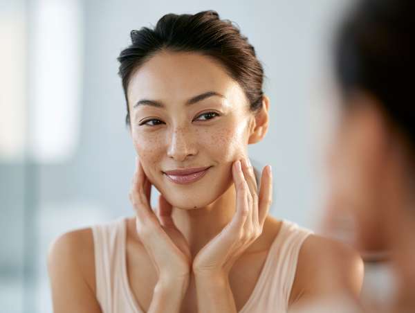 スキンケアを楽しむ自然な笑顔の女性