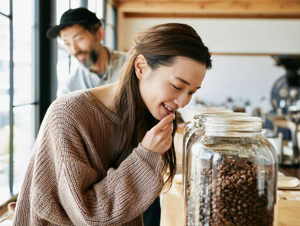 コーヒー豆の香りを楽しむ女性