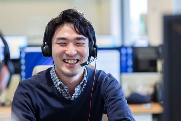 笑顔で電話対応する男性オペレーター