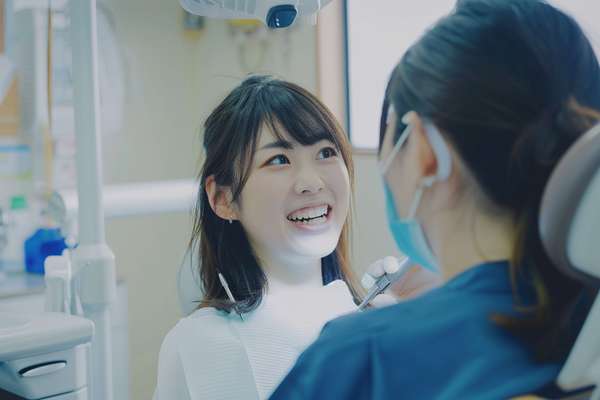 歯科医院で治療を受ける笑顔の女性患者