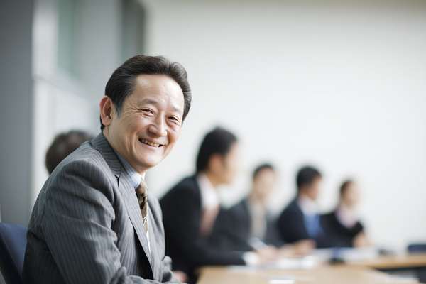 会議で笑顔を見せる日本人ビジネスマン