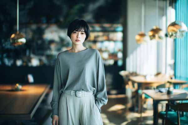 カフェで佇むショートカットの女性