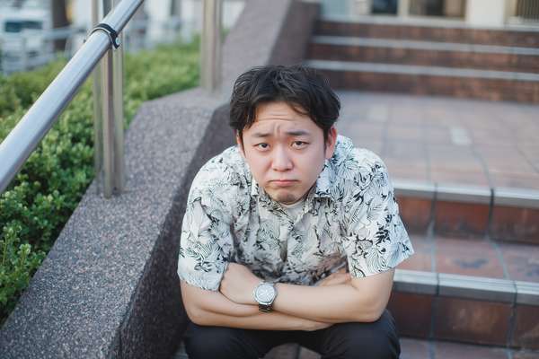 不満げな表情で座る若い男性