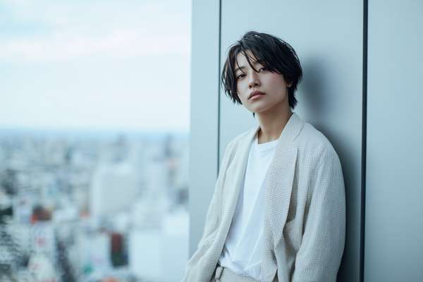 窓辺に立つショートヘアの男性