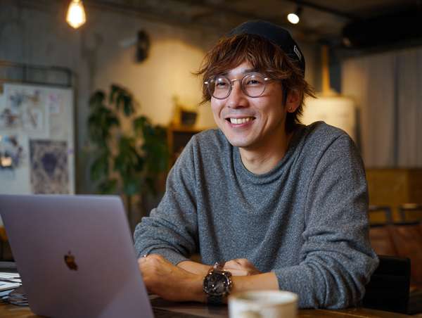 ノートパソコンで作業する笑顔の男性