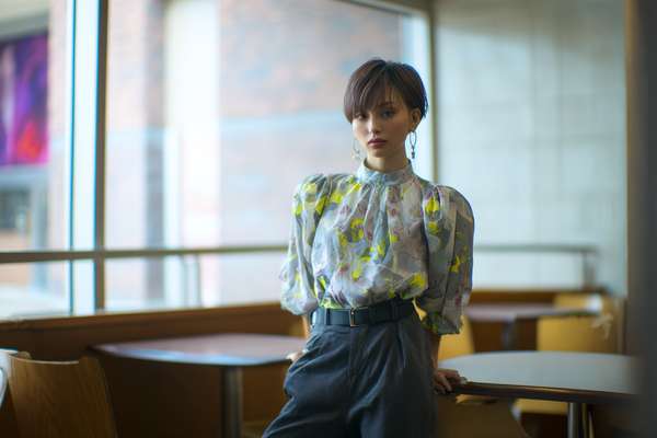 窓辺で佇むショートヘアの女性