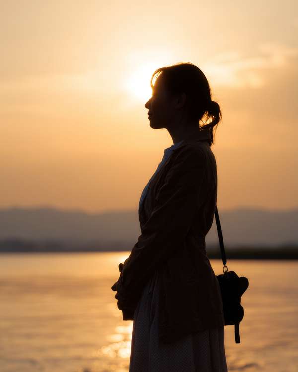 夕暮れ時に佇む女性のシルエット