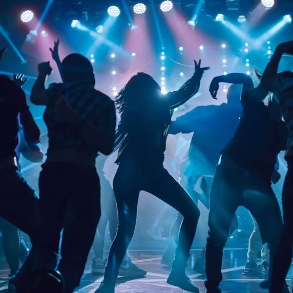 ステージで熱狂的に踊るダンサーたちのシルエット