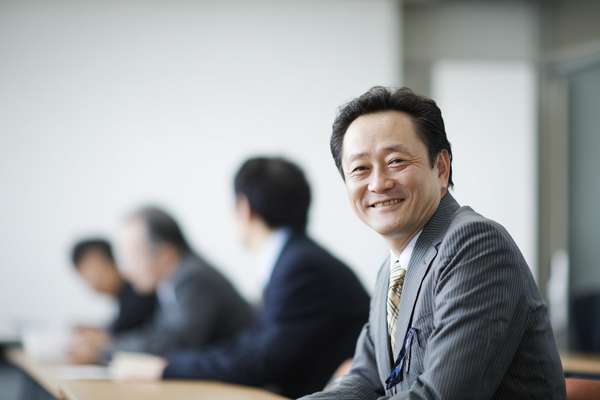 会議で笑顔を見せるビジネスマン