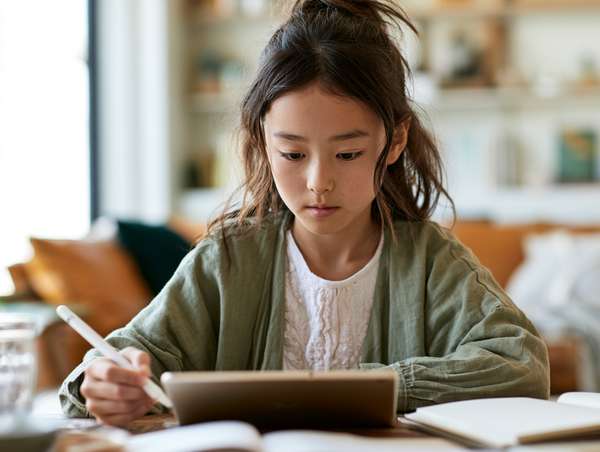 タブレットで学習する真剣な表情の少女