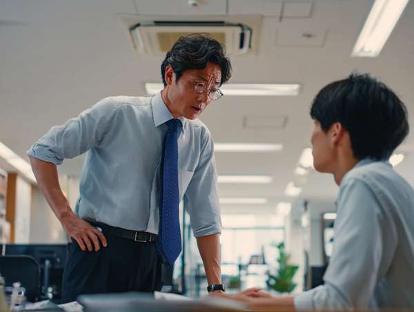 オフィスで部下を厳しく叱責する上司