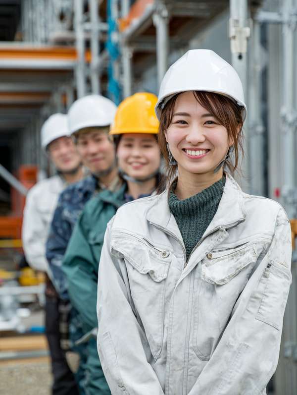 建設現場で並ぶ笑顔の作業員たち
