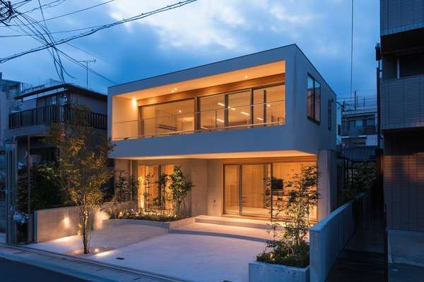 夕暮れ時にライトアップされたモダンな住宅の外観