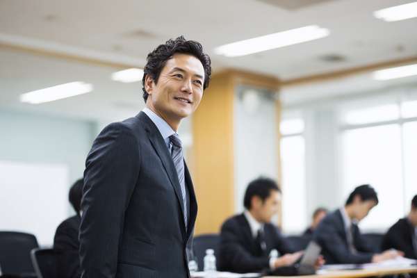会議で前を見据えるスーツ姿のビジネスマン