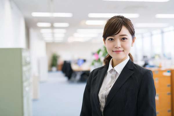 オフィスで微笑むスーツ姿の若い女性