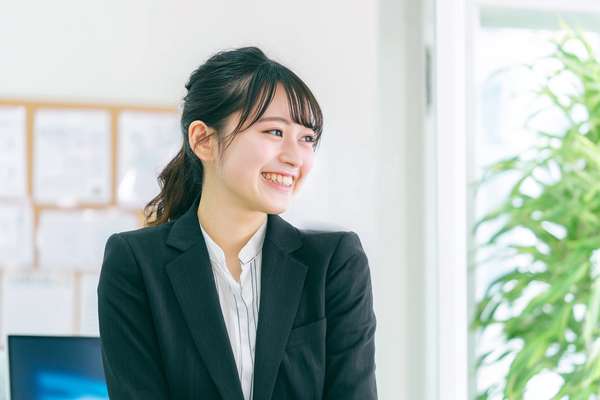オフィスで微笑むスーツ姿の若手女性社員
