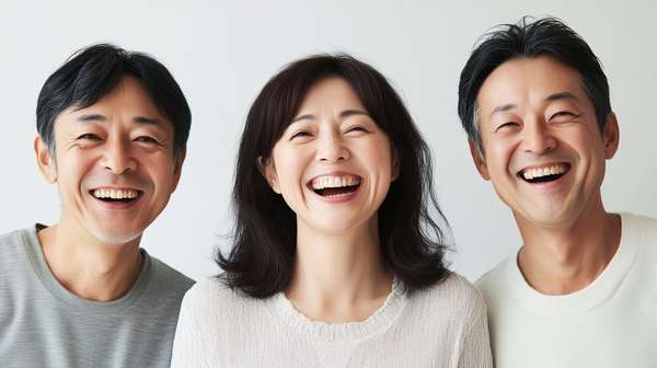 笑顔で並ぶアジア人の中年男女3人