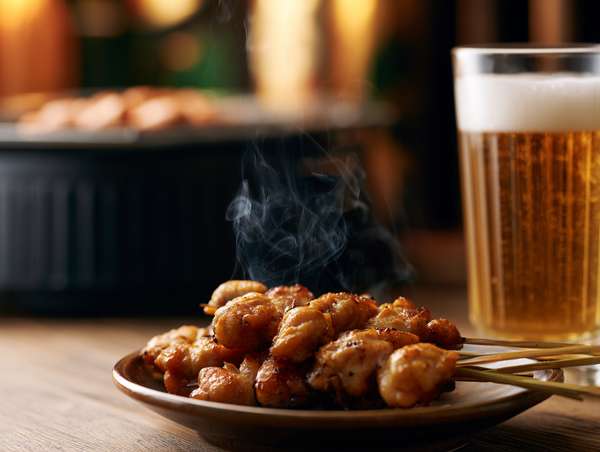 湯気が立つ焼き鳥とビール
