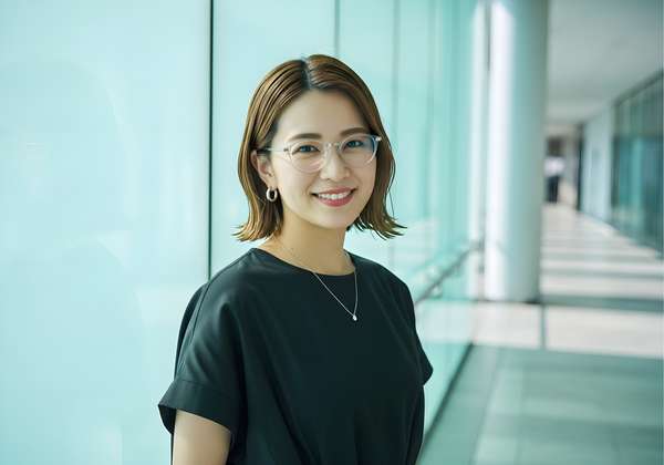 オフィスで微笑むメガネをかけた日本人女性
