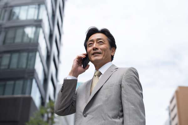 都会でスマートフォンで通話するビジネスマン