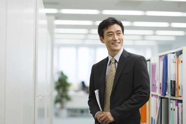 オフィスで微笑むスーツ姿の日本人ビジネスマン