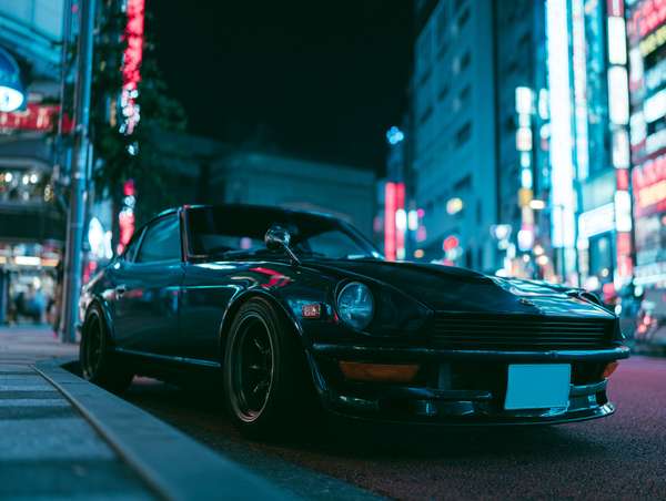 ネオン輝く夜の街に佇むヴィンテージカー