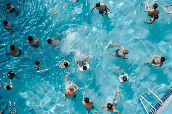 夏の屋外プールで泳ぐ大勢の人々