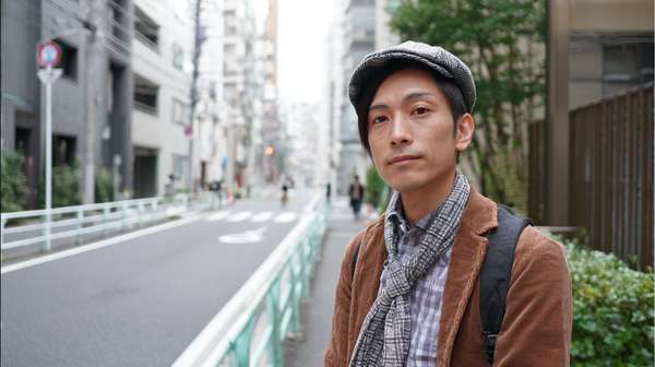 都会の街角に立つおしゃれな若い日本人男性